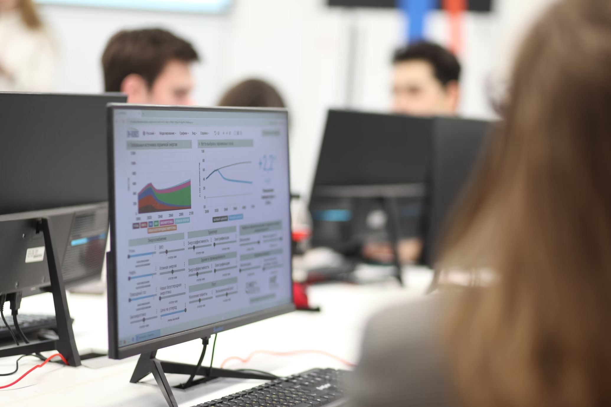 Computer screen with analytics and people on the background