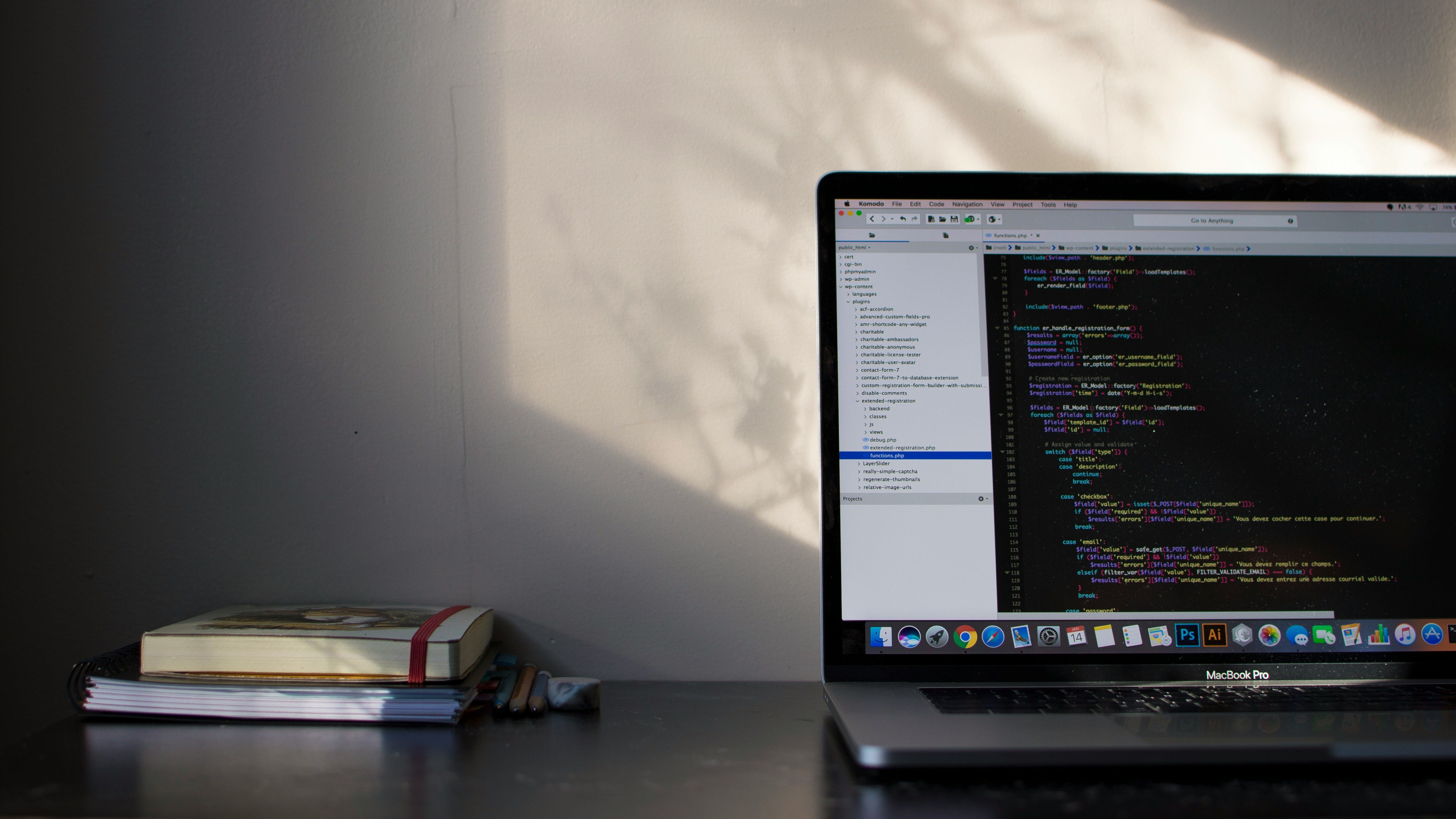 Laptop on a desk with notesbook