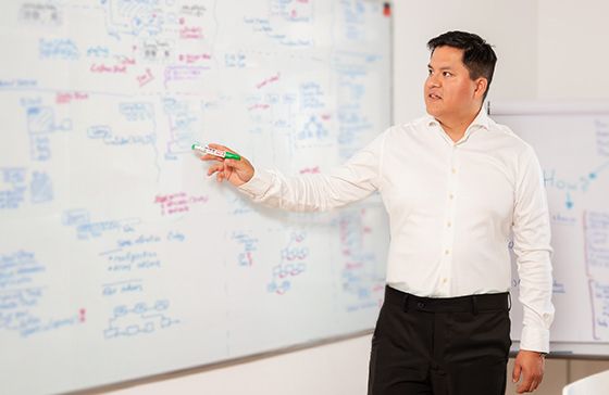 John presenting on a white board