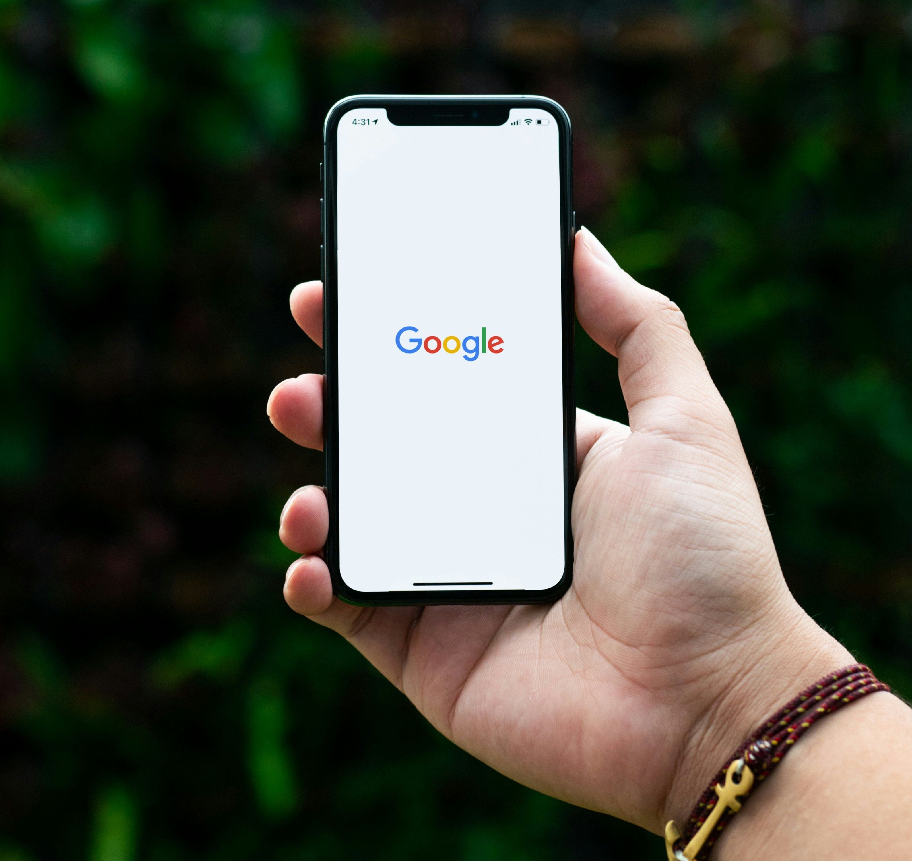 Hand holding a phone with the google logo