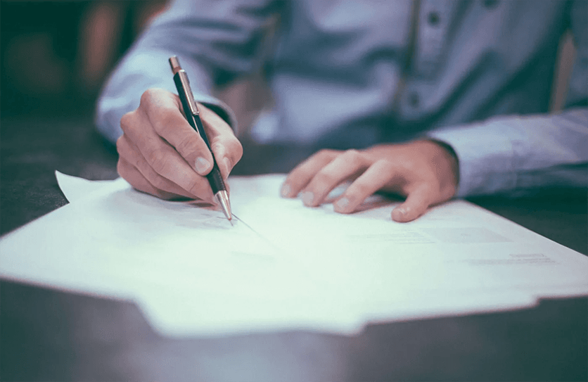 Man signing papers on a table